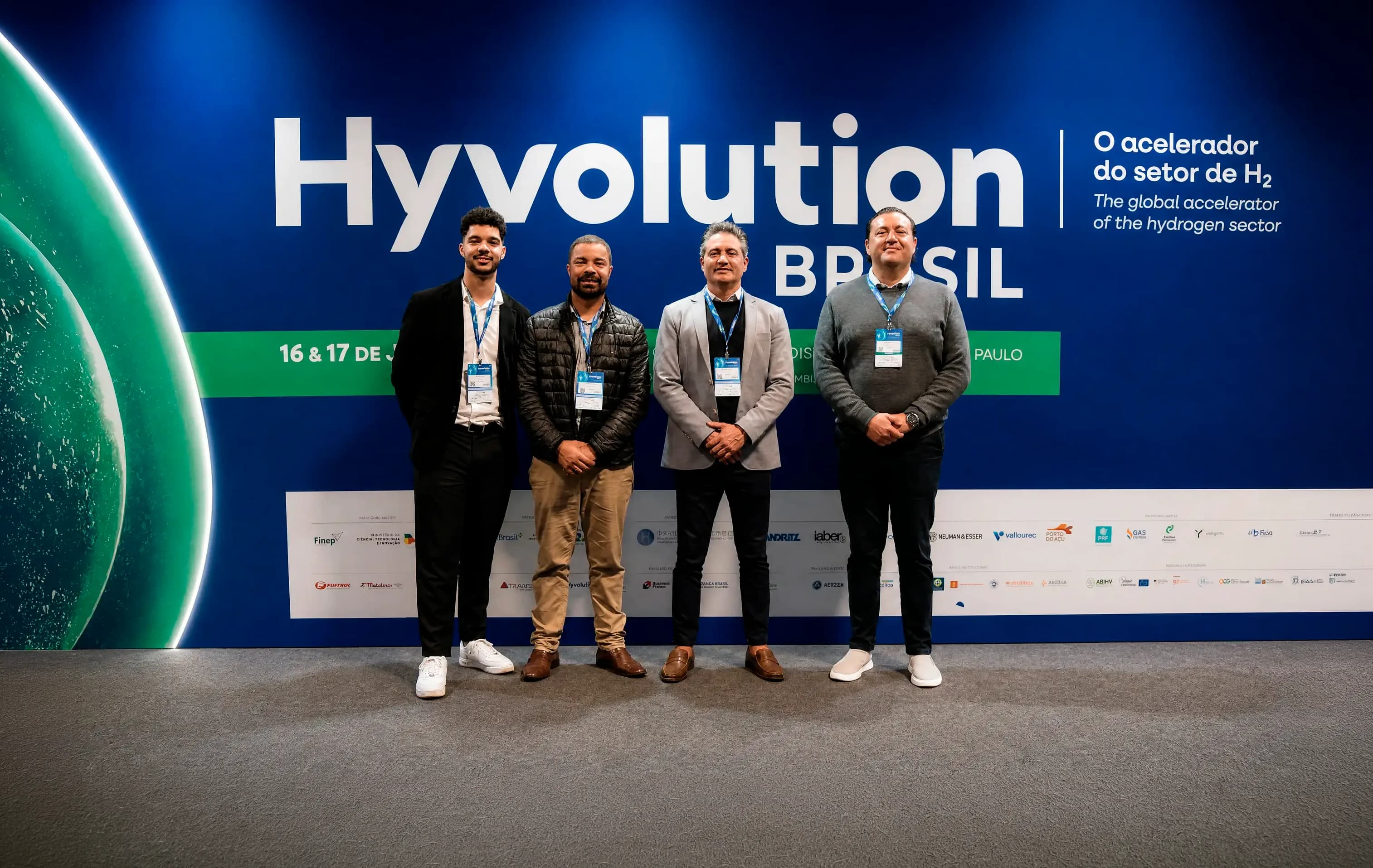Equipe da AHS Energia, com o CEO Denilson de Souza, em frente ao backdrop oficial da Hyvolution Brasil 2026, no Distrito Anhembi, em São Paulo